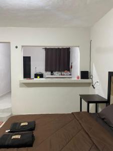 ein Schlafzimmer mit einem Bett und einem Tisch und einem Fenster in der Unterkunft ESTUDIO VACACIONAL in Cozumel