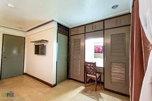 um quarto com uma porta, uma cadeira e uma janela em Caliraya Ecoville Recreation and Farm Resort em Cavinti