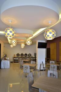 a dining room with tables and chairs and chandeliers at Zodiak Sutami by KAGUM Hotels in Bandung