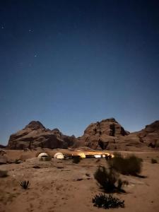 a desert at night with the stars in the sky at Zarb Desert Camp in Wadi Rum