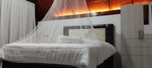 uma cama com uma rede mosquiteira num quarto em Nan Bungalows Tetebatu em Tetebatu
