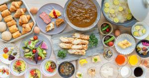 uma mesa coberta com pratos de comida e tigelas de comida em Grids Premium Hotel Kumamoto em Kumamoto