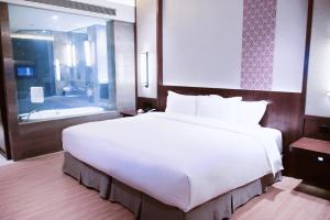 een groot wit bed in een kamer met een badkamer bij Neodalle Zhangjiajie Wulingyuan in Zhangjiajie