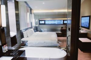 ein Hotelzimmer mit einem Bett und einem Bad in der Unterkunft Neodalle Zhangjiajie Wulingyuan in Zhangjiajie