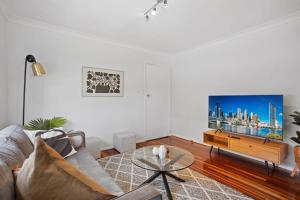 a living room with a couch and a table at Windsor Cosy 2-Bedroom Unit in Quiet Neighborhood in Brisbane