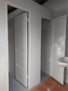 San Vicente de ChucuríにあるDe La Mora Hostal.の空のバスルーム(ドア、シンク付)