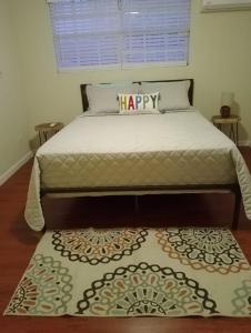 a bed with a happy pillow on top of it at The Sweet Oasis 2 bedroom Apartment in Nassau