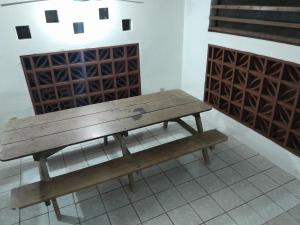 eine Holzbank in einem Zimmer mit Weinregalen in der Unterkunft Sarita's House in Esterillos Este