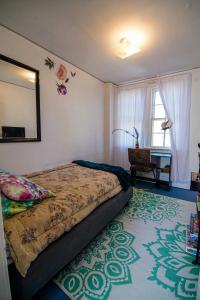 Schlafzimmer mit einem Bett und einem Wandspiegel in der Unterkunft Healthy Greenery - Urban Retreat in Rock Hill in Rock Hill