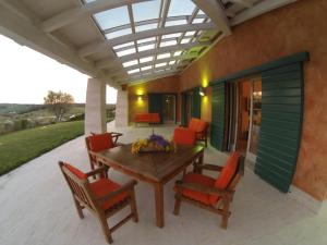 a patio with a wooden table and chairs at Villa Stella Relax in Saturnia