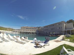 a group of lounge chairs sitting next to a swimming pool at Villa Stella Relax in Saturnia