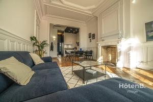a living room with a blue couch and a table at The "Heritage" Heart of Limoges Parking AC and Private Terrace in Limoges