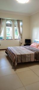 - une chambre avec un grand lit et 2 fenêtres dans l'établissement Luzira port bell lake side apartment, à Kampala