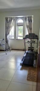 een lege kamer met een loopband in een kamer met ramen bij Luzira port bell lake side apartment in Kampala