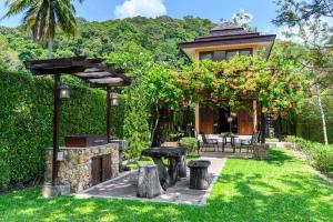 uma casa com um jardim com um pátio em Garden Cottage em Ko Chang