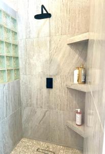 een badkamer met een douche met marmeren muren en planken bij Brand NEW Casita Clásica in El Pescadero