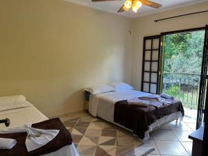 康斯沃托雅的住宿－Pousada dos Girassóis，一间卧室设有两张床和大窗户