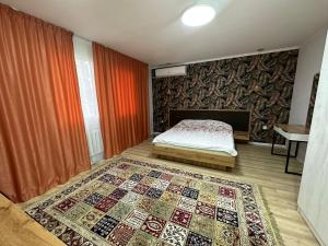 1 dormitorio con cama y alfombra en el suelo en Гостиничный ресторанный комплекс Эдельвеис, en Öskemen
