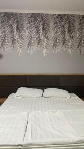 1 cama con 2 almohadas y una pared con agujas de pino en Гостиничный ресторанный комплекс Эдельвеис, en Öskemen
