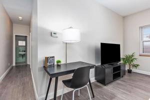 a dining room with a desk and a tv in a room at 2BR Heritage Hill Apt Long Stay Discount in Grand Rapids