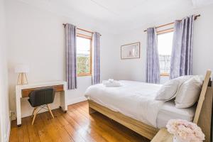 Schlafzimmer mit einem Bett, einem Schreibtisch und einem Fenster in der Unterkunft Feels like your home ! in Auckland