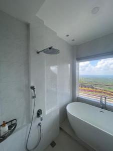 a white bathroom with a tub and a window at manca kemetug in Blimbing