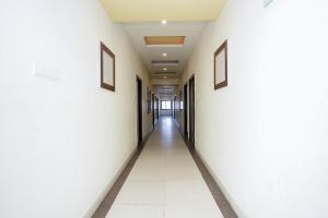 an empty corridor of an office building with white walls and a long hallway at Hotel Opera Inn in Udaipur