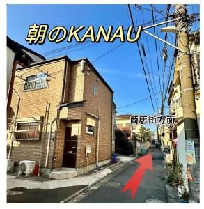 a brick building with a red arrow on the street at KANAU in Tokyo