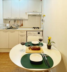 Una mesa con un plato de comida y dos copas de vino. en La Tulipe, en Seúl