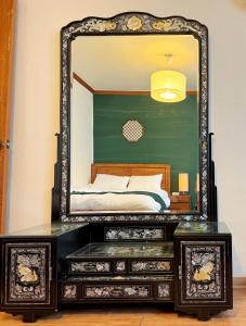 un espejo encima de un tocador en un dormitorio en La Tulipe en Seúl