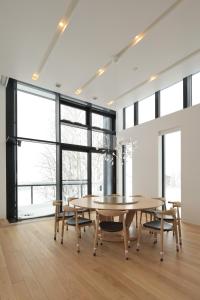 a dining room with a table and chairs and large windows at ZEN - Vacation STAY 74302v in Niseko
