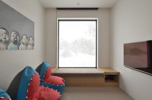 a room with a window with a couch and a tv at ZEN - Vacation STAY 74302v in Niseko