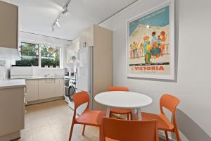 eine Küche und ein Esszimmer mit einem Tisch und Stühlen in der Unterkunft Urban Retro - Experience Vibrant Courtyard Charm in Melbourne