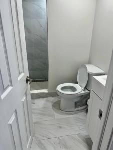 La salle de bains blanche est pourvue de toilettes et d'un lavabo. dans l'établissement Cozy Studio Bsmt in Scarborough Central, à Toronto