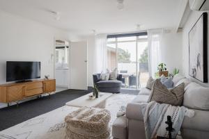 a living room with a couch and a tv at Uncover Mount Eliza's Charm from this Local Stay in Mount Eliza