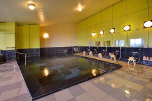 Cette chambre dispose d'une piscine avec des chaises. dans l'établissement Hotel Seiryu Japanese Spa inn with spectacular view in Osaka, à Higashiōsaka