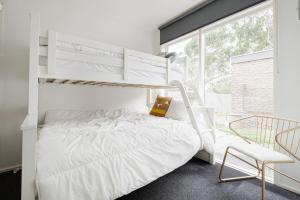 a bedroom with a white bunk bed and a chair at Uncover Mount Eliza's Charm from this Local Stay in Mount Eliza