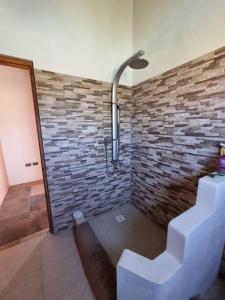 uma casa de banho com uma parede de tijolos e um chuveiro em Casa Ohana San Pedro de Atacama em San Pedro de Atacama