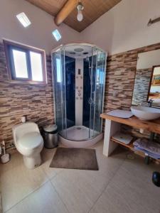 uma casa de banho com um chuveiro, um WC e um lavatório. em Casa Ohana San Pedro de Atacama em San Pedro de Atacama