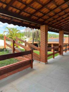 a pavilion with wooden benches and a brick pillar at Linda chácara reformada. in Itu