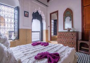 a bedroom with a large bed and a dresser at Riad Mamma MARRAKESH in Marrakesh