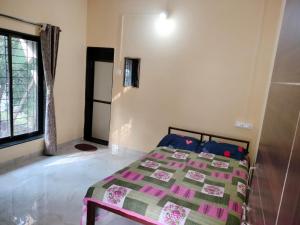 A bed or beds in a room at Patkar's Vaishnavi Niwas - Home Stay