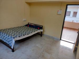 A bed or beds in a room at Patkar's Vaishnavi Niwas - Home Stay