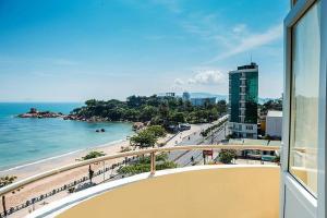 - un balcon avec vue sur la plage et un bâtiment dans l'établissement Phòng khách sạn 3 sao, à Nha Trang