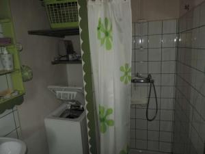 La salle de bains est pourvue d'un rideau de douche avec des fleurs vertes. dans l'établissement Maison Noirmoutier-en-l'Île, 2 pièces, 4 personnes - FR-1-224B-214, à Noirmoutier-en-l'lle