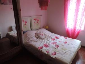 - une chambre avec un lit orné de roses dans l'établissement Maison Noirmoutier-en-l'Île, 2 pièces, 4 personnes - FR-1-224B-214, à Noirmoutier-en-l'lle