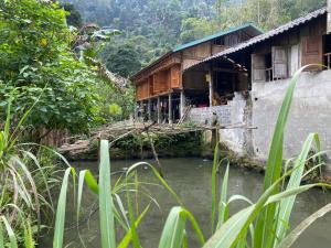a house with a bridge over a river at Bikki jungle homestay in Ha Giang