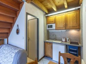 eine kleine Küche mit einem Bett und einer Mikrowelle in der Unterkunft Appartement Cauterets, 2 pièces, 4 personnes - FR-1-401-286 in Cauterets