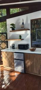 a kitchen with a white counter top and wooden cabinets at Willo's Treehouse in Escuintla