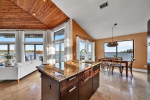 a kitchen and dining room with a view of the ocean at Experience breathtaking sunsets on Bluewater Bay! Private dock, 15 minute boat ride to Crab Island, 20 minute drive to Destin, Pet Friendly in Niceville